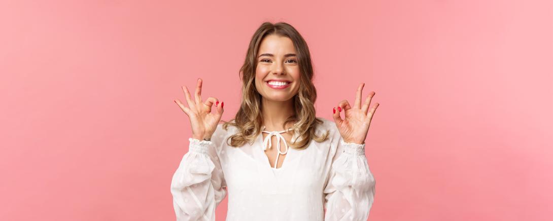 Femme souriante faisant signe que tout va bien avec les mains